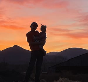 Brother and sister in front of a beautiful sunset in the mountains
